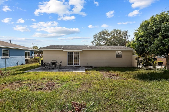 rear view of house with a yard and a patio