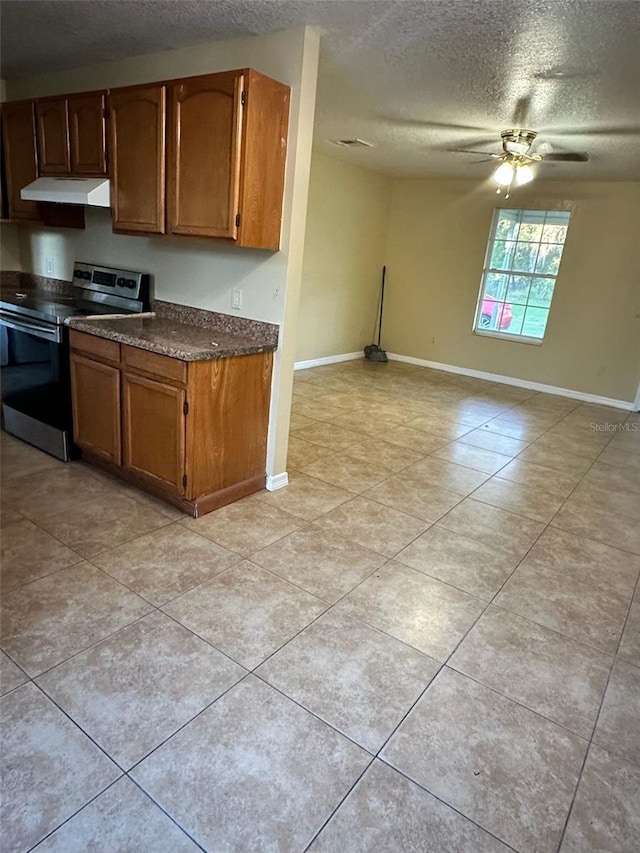 kitchen featuring stainless steel electric range, ceiling fan, light tile patterned flooring, and a textured ceiling