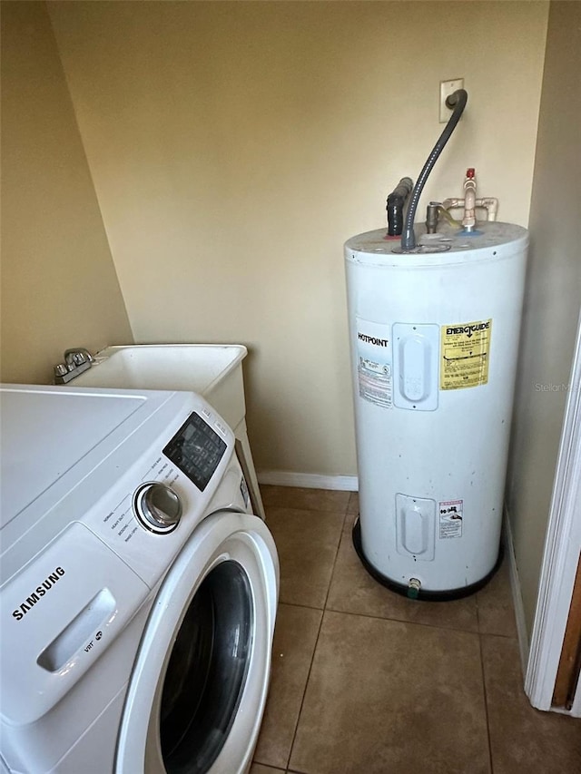 washroom with washer / clothes dryer, electric water heater, and dark tile patterned floors