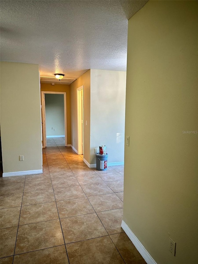 hall with light tile patterned floors and a textured ceiling