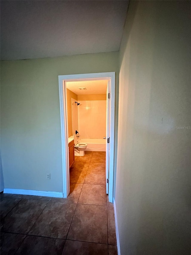 hall with tile patterned floors