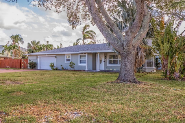 ranch-style house featuring a garage and a front lawn