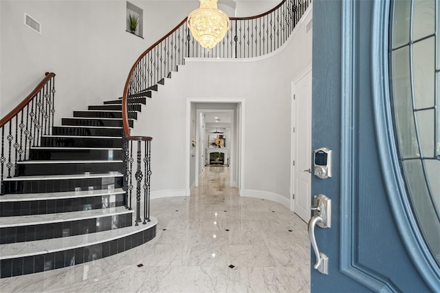 entrance foyer featuring a towering ceiling and an inviting chandelier