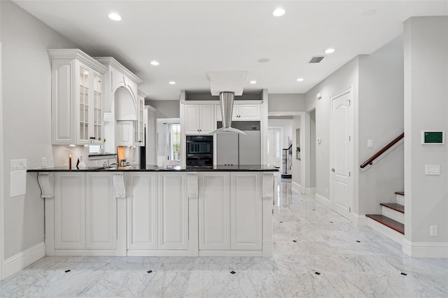 kitchen featuring white cabinets, kitchen peninsula, and built in refrigerator