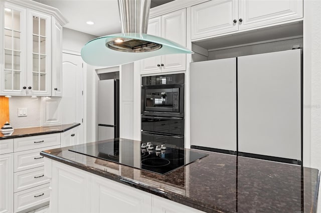 kitchen featuring dark stone counters, white cabinets, and black appliances