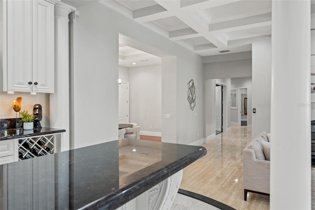 bar with white cabinetry, coffered ceiling, light hardwood / wood-style flooring, beamed ceiling, and crown molding