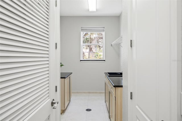 clothes washing area featuring light tile patterned floors