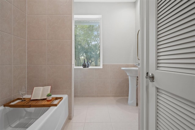 bathroom featuring tile patterned floors, tile walls, and a tub