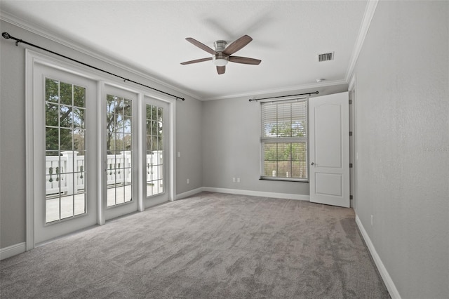 empty room featuring carpet, plenty of natural light, ornamental molding, and ceiling fan