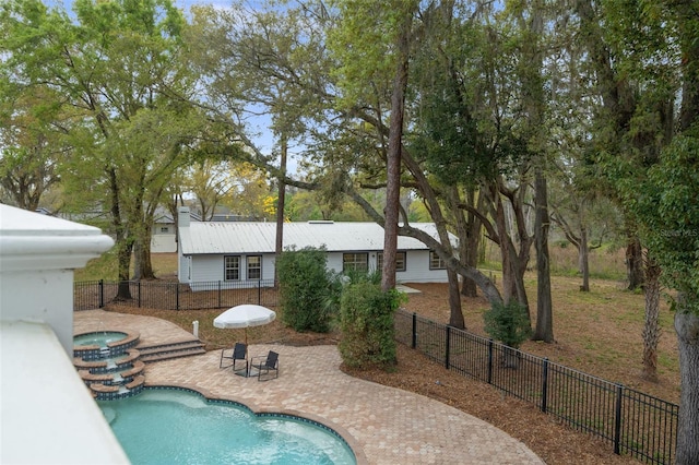 view of swimming pool featuring a patio area and an in ground hot tub