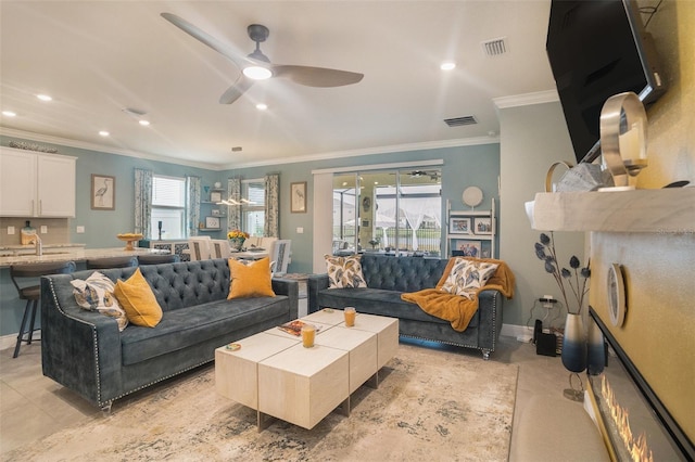 living room with ceiling fan and ornamental molding