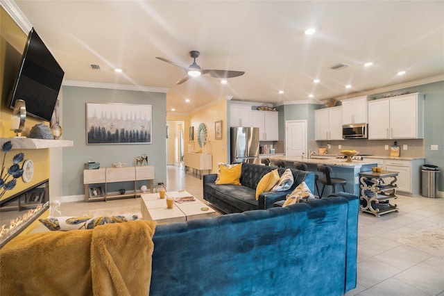 living room featuring ceiling fan, light tile patterned flooring, and ornamental molding