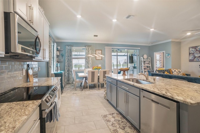 kitchen with ornamental molding, stainless steel appliances, white cabinetry, and gray cabinetry