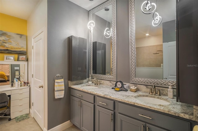 bathroom featuring tile patterned flooring, vanity, and tiled shower