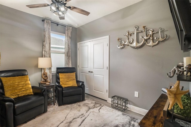 sitting room with ceiling fan, light wood-type flooring, and vaulted ceiling