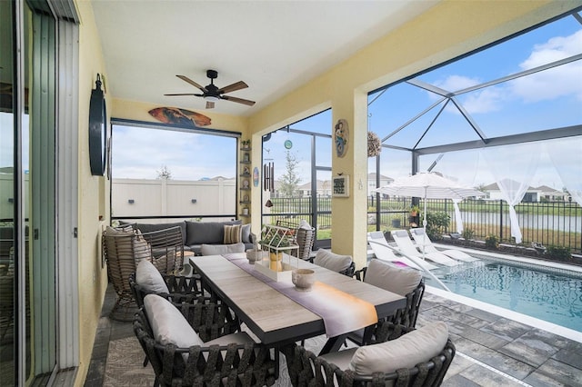 sunroom / solarium featuring a water view, ceiling fan, and a swimming pool