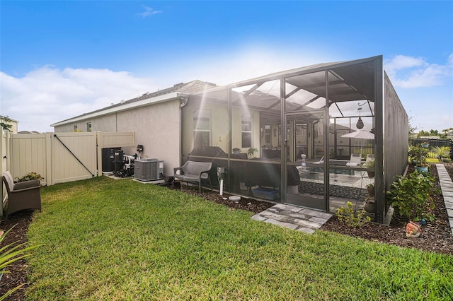 rear view of property featuring a pool, a yard, glass enclosure, and central AC unit