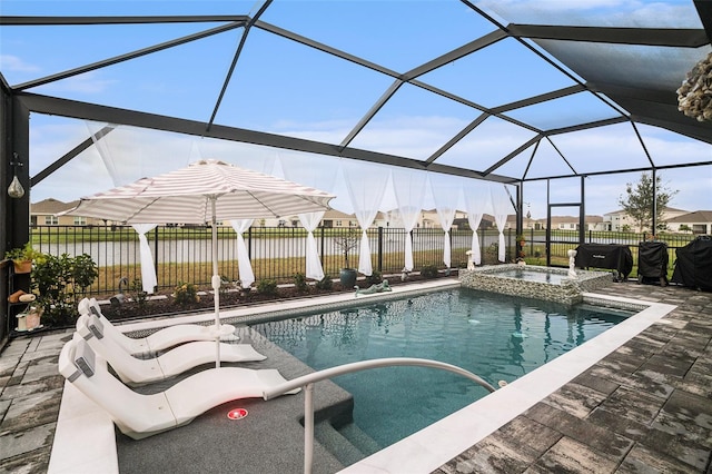 view of pool featuring glass enclosure, a patio area, and an in ground hot tub