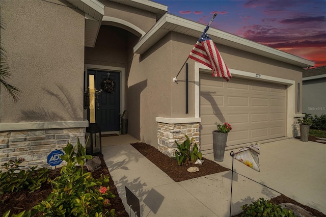 exterior entry at dusk with a garage