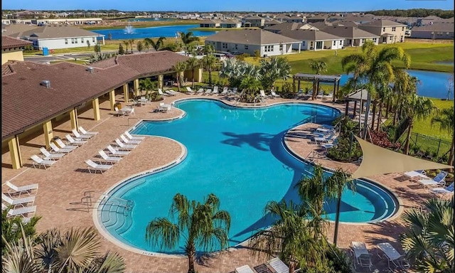 view of pool with a patio and a water view