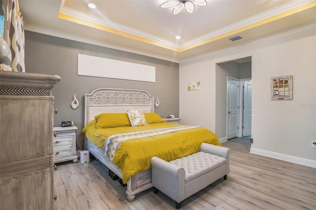 bedroom with a textured ceiling, hardwood / wood-style flooring, a raised ceiling, and crown molding