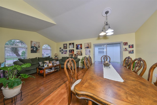 dining space featuring a notable chandelier, dark hardwood / wood-style flooring, and vaulted ceiling