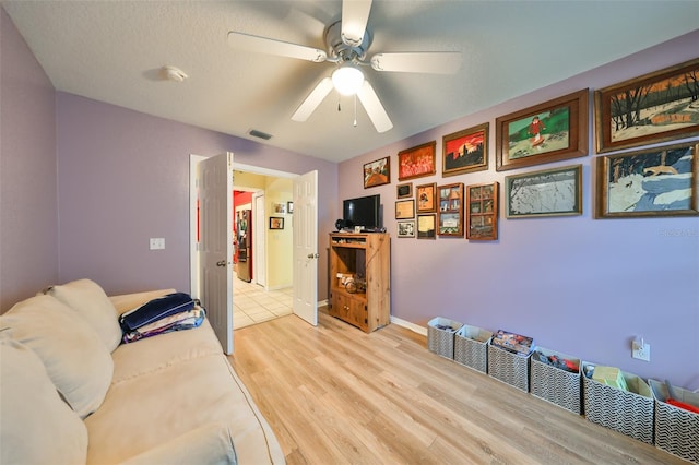 interior space with ceiling fan, light hardwood / wood-style floors, and a textured ceiling