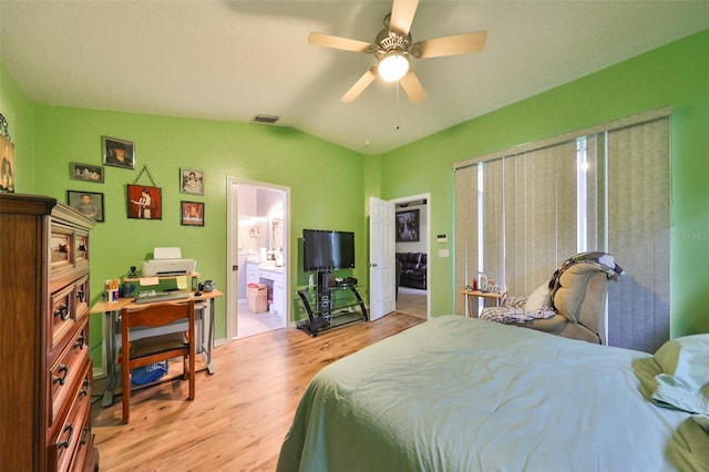 bedroom featuring ceiling fan, lofted ceiling, light hardwood / wood-style flooring, and ensuite bath