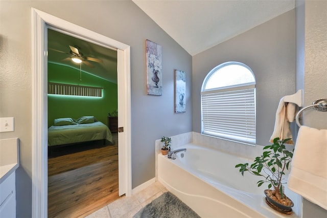 bathroom with vanity, wood-type flooring, lofted ceiling, and a bath