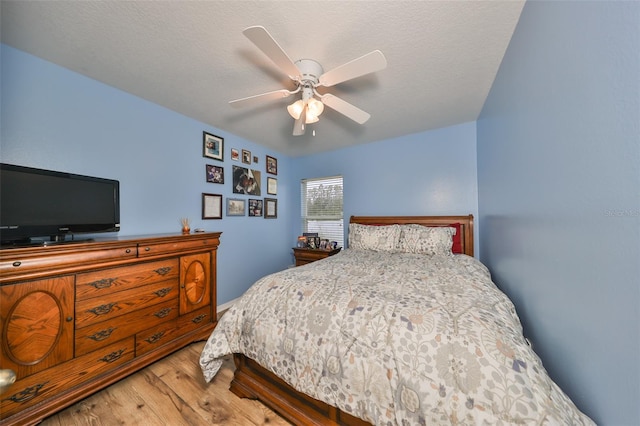 bedroom with hardwood / wood-style floors, a textured ceiling, and ceiling fan