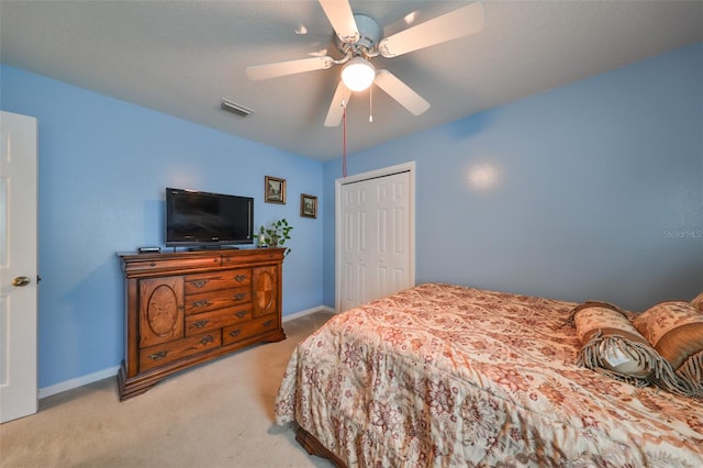 bedroom with ceiling fan, a closet, and light colored carpet