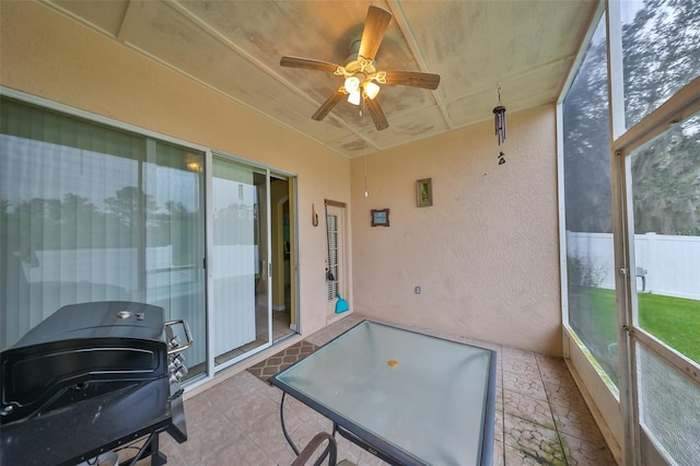 sunroom / solarium featuring ceiling fan and a healthy amount of sunlight