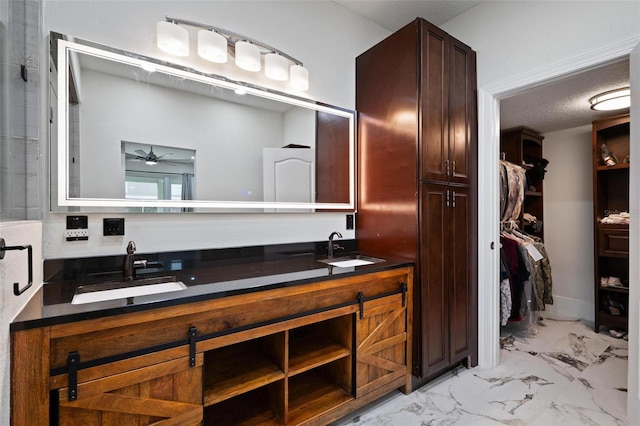 bathroom featuring a textured ceiling, vanity, and ceiling fan