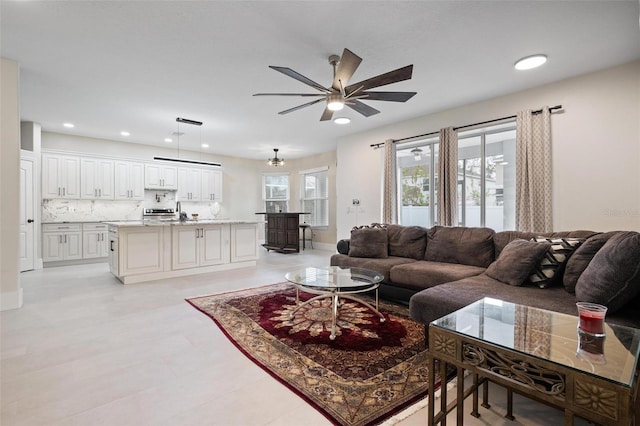 living room with recessed lighting, baseboards, and a ceiling fan