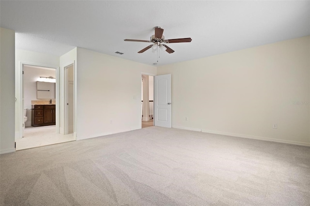 unfurnished bedroom with visible vents, light carpet, a ceiling fan, connected bathroom, and baseboards