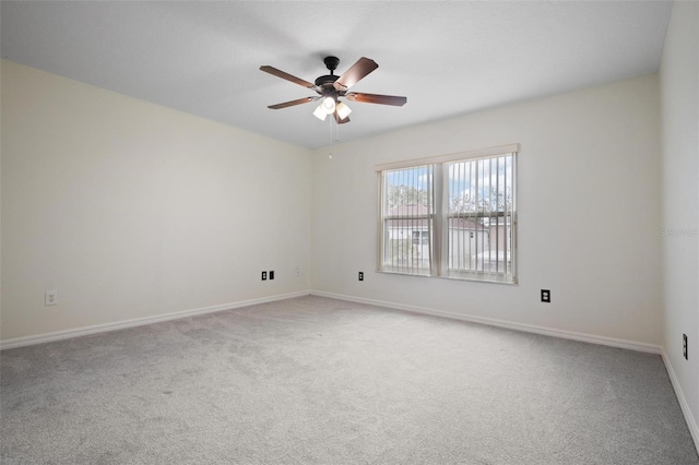 carpeted empty room featuring baseboards and ceiling fan