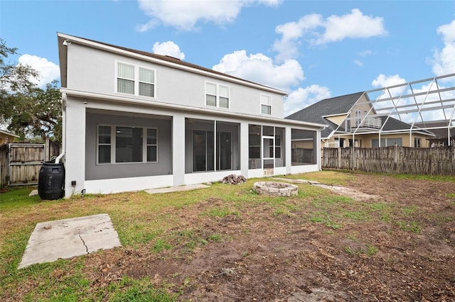 rear view of house featuring a yard and an outdoor fire pit