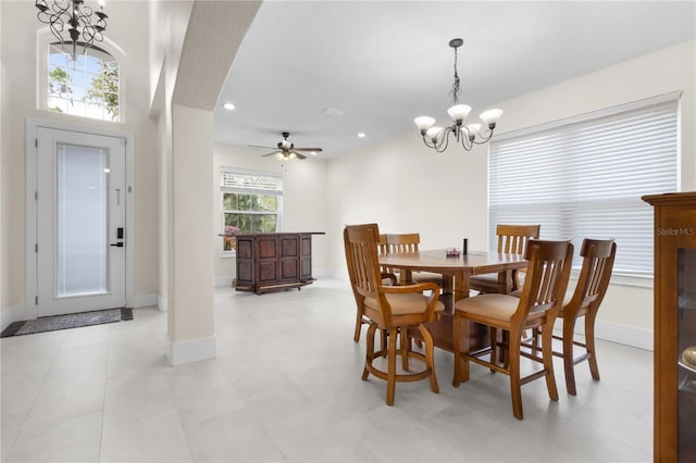 dining space featuring recessed lighting, baseboards, arched walkways, and ceiling fan with notable chandelier