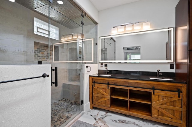 full bath featuring double vanity, a stall shower, marble finish floor, and a sink