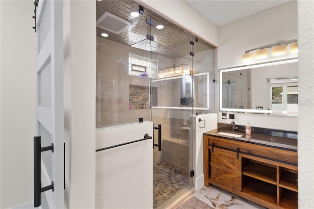 full bath featuring vanity, a shower stall, visible vents, and marble finish floor