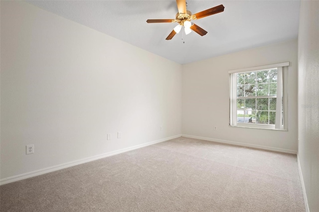 carpeted spare room with baseboards and ceiling fan