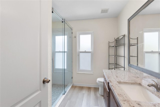 bathroom featuring visible vents, a shower stall, toilet, and vanity