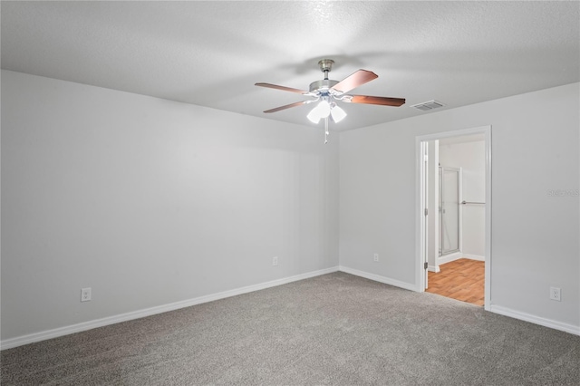 carpeted empty room featuring ceiling fan and a textured ceiling