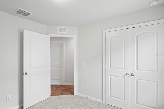 unfurnished bedroom featuring light colored carpet and a closet