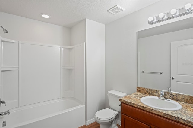 full bathroom with vanity, toilet, washtub / shower combination, and a textured ceiling