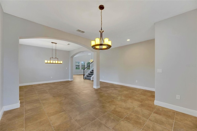 tiled empty room featuring a notable chandelier