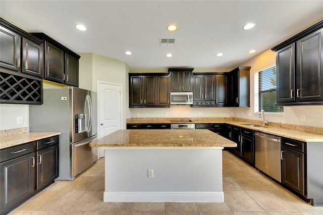 kitchen featuring a kitchen island, light tile patterned floors, and appliances with stainless steel finishes