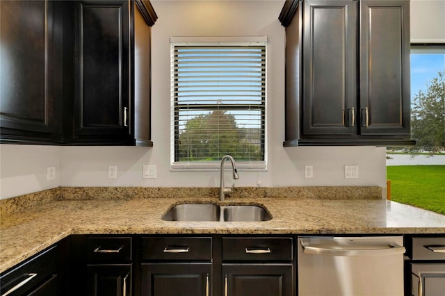 kitchen featuring dishwasher, a healthy amount of sunlight, light stone countertops, and sink