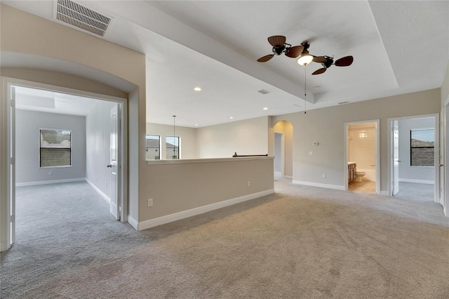 carpeted spare room featuring a wealth of natural light and ceiling fan