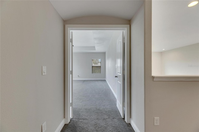 hallway with carpet floors and vaulted ceiling